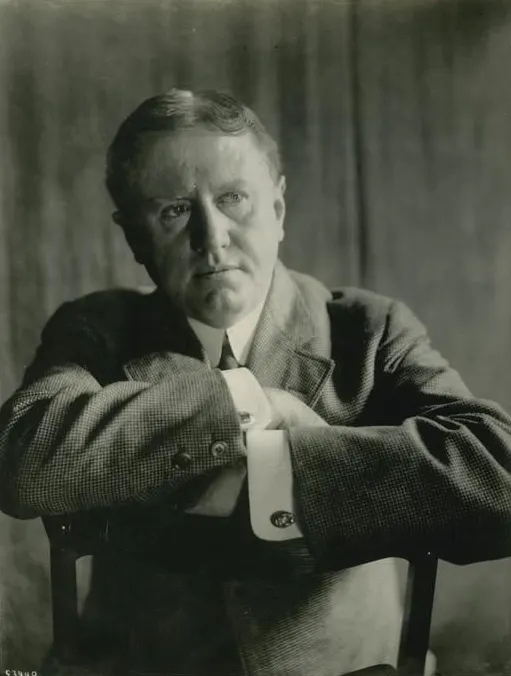 Portrait d'O. Henry, assis avec les bras posés sur le dossier d'une chaise