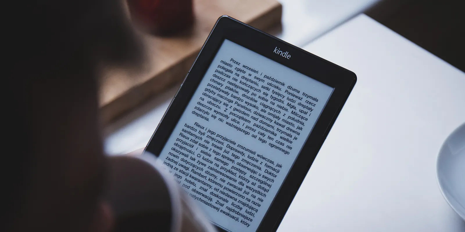 Lector electrónico con un libro abierto sobre una mesa de café